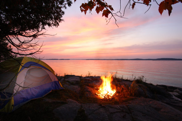 tent near water by a fire